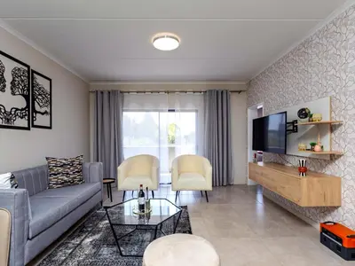 a living room with a couch and a tv at Glen Haven in Midrand