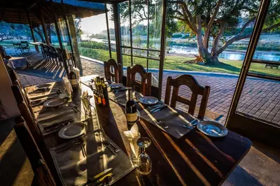 a long table with chairs and wine bottles on it at Maninghi Lodge in Balule Game Reserve
