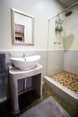 a bathroom with a sink and a mirror and a shower at Maninghi Lodge in Balule Game Reserve