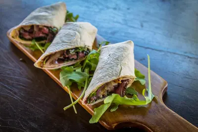 two sandwiches on a wooden plate on a table at Maninghi Lodge in Balule Game Reserve