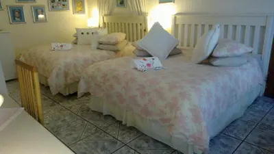 a bedroom with two beds with pillows on them at Harmony Guesthouse in Nelspruit