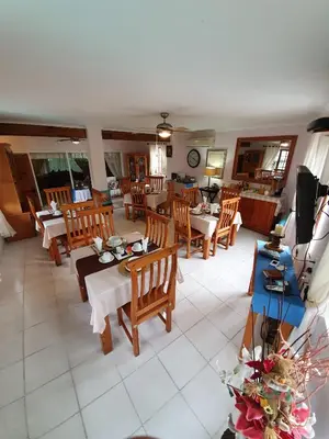 a living room with wooden tables and chairs at Harmony Guesthouse in Nelspruit