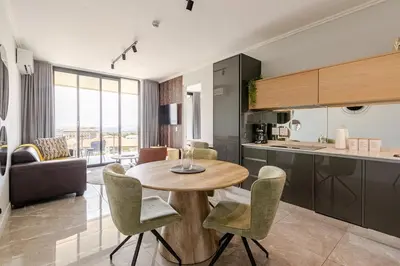 a kitchen and living room with a table and chairs at Jabba at Ellipse Waterfall in Midrand