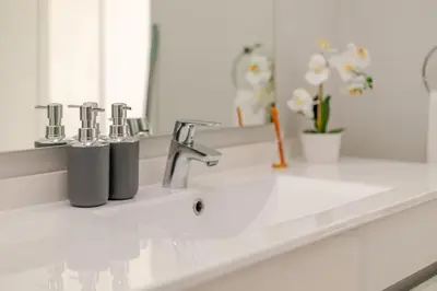 a white bathroom counter with a sink and a mirror at Jabba at Ellipse Waterfall in Midrand