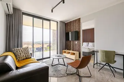 a living room with a couch and a bed and a desk at Jabba at Ellipse Waterfall in Midrand