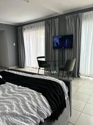 a bedroom with a bed and a table and chairs at Serene Oasis in Tierpoort