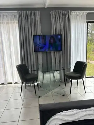 a dining room with a glass table and two chairs at Serene Oasis in Tierpoort