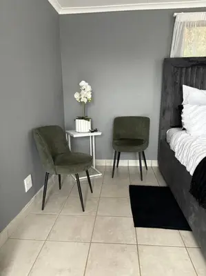 a bedroom with a bed and two chairs and a table at Serene Oasis in Tierpoort