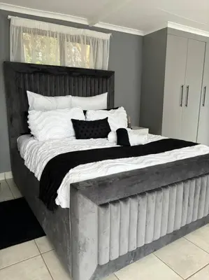 a bedroom with a large bed with black and white pillows at Serene Oasis in Tierpoort