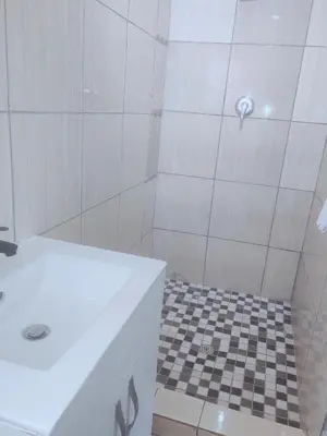 a bathroom with a shower with a checkered floor at Choosers Express Hotel Room 6 in Rooihuiskraal