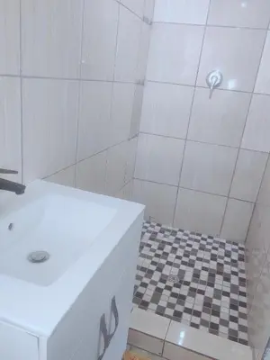 a bathroom with a shower with a white sink at Choosers Express Hotel Room 6 in Rooihuiskraal