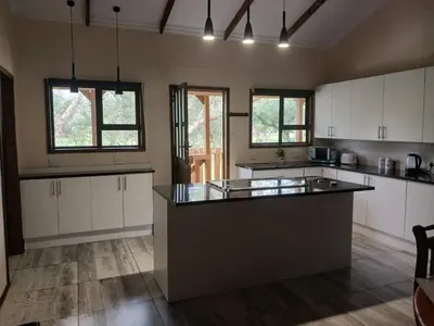 a large kitchen with white cabinets and a large island at Hippo Waterfront Lodge in Nelspruit