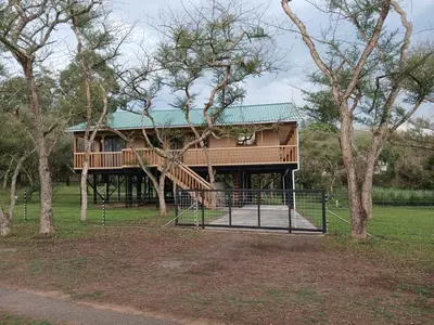 a tree house with a porch and a playground at Hippo Waterfront Lodge in Nelspruit