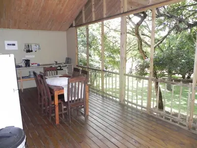 a screened in porch with a table and chairs at Hippo Waterfront Lodge in Nelspruit