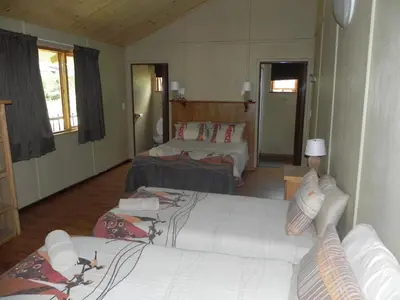 a hotel room with two beds and a living room at Hippo Waterfront Lodge in Nelspruit