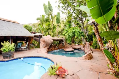 a swimming pool in a garden with a resort at 61 On Ireland Guest House and Conferencing in Polokwane