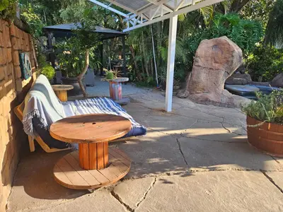 a wooden table and a bench and a table and a table and a table at 61 On Ireland Guest House and Conferencing in Polokwane