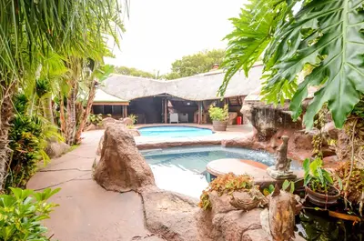 a swimming pool in a yard next to a house at 61 On Ireland Guest House and Conferencing in Polokwane