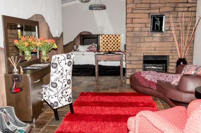 a living room with a bed and a fireplace at 61 On Ireland Guest House and Conferencing in Polokwane