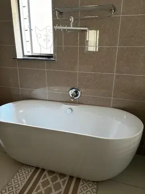a white bath tub in a bathroom with a window at Micasa apartments in Midrand
