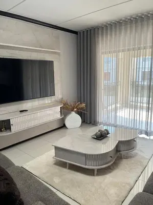 a living room with a large television and a table at Micasa apartments in Midrand
