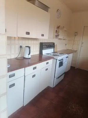 a kitchen with white cabinets and a stove top oven at mokede Iin in Pretoria