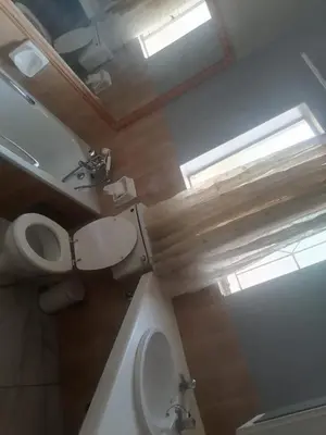 a bathroom with a toilet and a sink and a window at mokede Iin in Pretoria