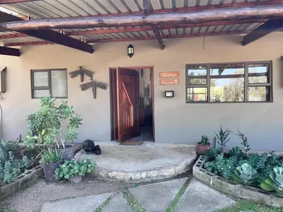 a front door of a house with a cat laying in front at Mananga Bush Villa in Skukuza