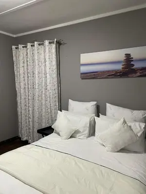 a large white bed with white pillows in a bedroom at White House in Kempton Park