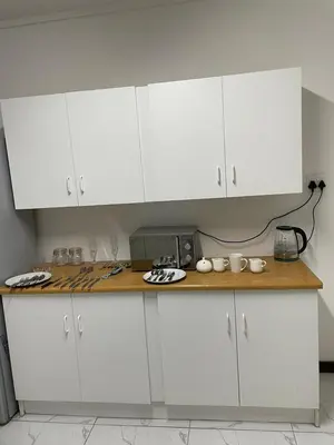 a kitchen with white cabinets and a counter top at Torremolinos City in Kempton Park