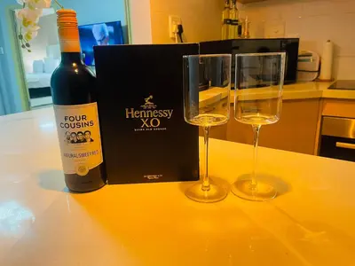 a bottle of wine and two wine glasses on a counter at 12th La Maison in Erand