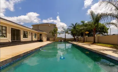 a swimming pool with a hose in front of a house at 12th La Maison in Erand