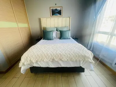 a bedroom with a large bed with blue pillows at 12th La Maison in Erand