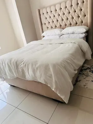 a bed with a white comforter and pillows on it at Tranquility in Erand