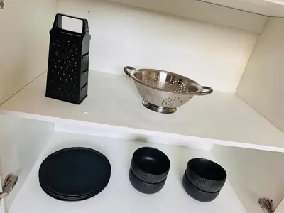 a shelf with a bowl and four black plates at Tranquility in Erand