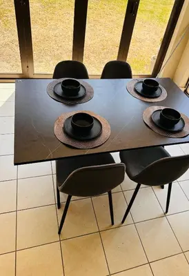 a dining room table with four chairs and hats on it at Tranquility in Erand