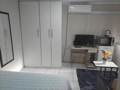 a living room with a couch and a desk with a computer at Angel Secure Unit in Pretoria