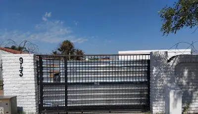a black gate on a white brick wall at Angel Secure Unit in Pretoria