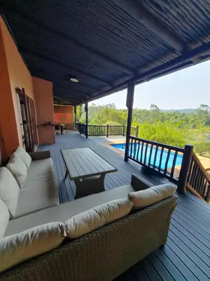 a porch with a couch and a table on a deck at DaGama Dam - White River - Martial Eagle - C23 in Swartfontein