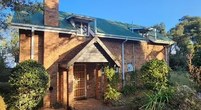 an old brick house with a green roof at Country Cottage in Koppie Alleen