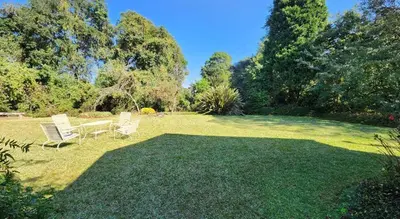 a yard with two chairs and a table in the grass at Country Cottage in Koppie Alleen