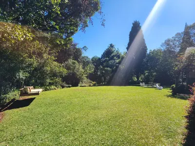 a large grassy field with a rainbow in the sky at Country Cottage in Koppie Alleen
