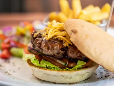 a sandwich on a plate with a salad and french fries at Hazyview Cabanas in Hazyview