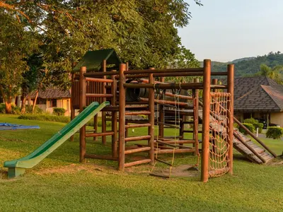 a wooden playground with a slide and a slideintend at Hazyview Cabanas in Hazyview