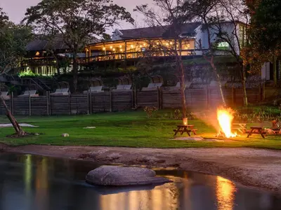 a fire pit with a building in the background at Hazyview Cabanas in Hazyview