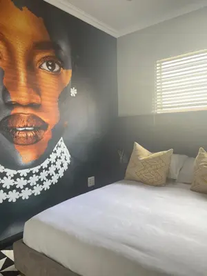 a bedroom with a large painting of a woman at Anga Spaces in Duvhapark