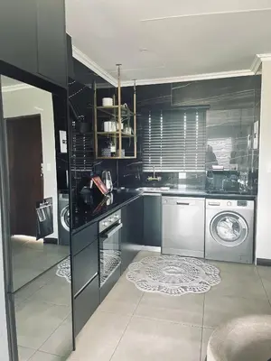a large kitchen with a washer and dryer at Anga Spaces in Duvhapark