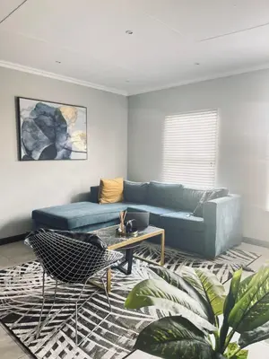 a living room with a blue couch and a table at Anga Spaces in Duvhapark