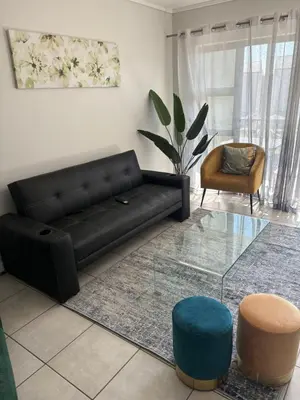 a living room with a black couch and a chair at Chaka at TheCreek in Pretoria