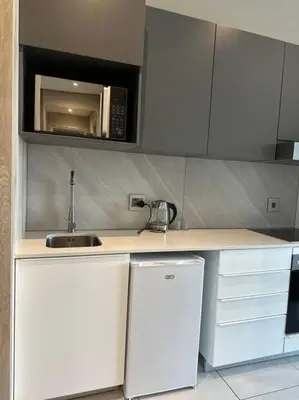 a white kitchen with a sink and a microwave at Menlyn Maine Golden Sands in Pretoria